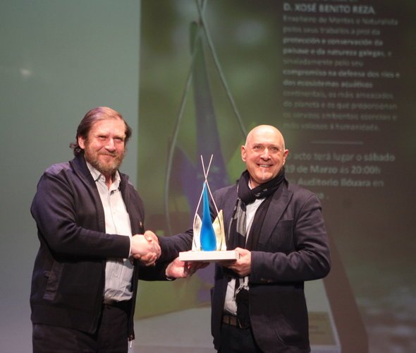José Benito Reza, a la izquierda, recibe el premio de manos del escultor Toño Monteiro.
